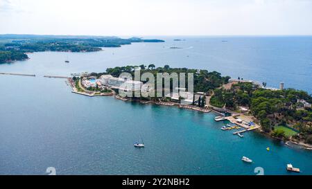 Porec, Istrien, Kroatien - 26. August 2024: Luftaufnahme der Insel Otok Sveti Nikola vor der Küste von Porec, Kroatien. Diese idyllische Insel ist bekannt für ihre Resorts, Strände und das klare blaue Wasser der Adria *** Luftaufnahme der Insel Otok Sveti Nikola vor der Küste von Porec, Kroatien. Diese idyllische Insel ist bekannt für ihre Resorts, Strände und das klare, blaues Wasser der Adria Stockfoto