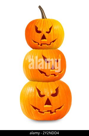 Stapel Kürbisse mit geschnitzten gruseligen Gesichtern auf weißem Hintergrund. Halloween Jack-o-Lampions in verschiedenen Größen Stockfoto