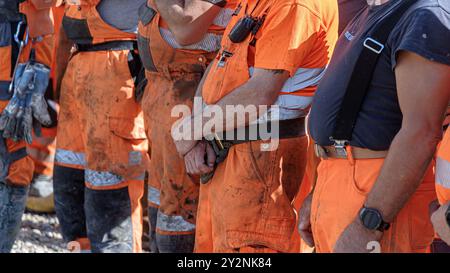 Hamburg, Deutschland. August 2024. Eine Gruppe von Bauarbeitern steht während einer Pause auf einer Baustelle zusammen. Quelle: Markus Scholz/dpa/Alamy Live News Stockfoto