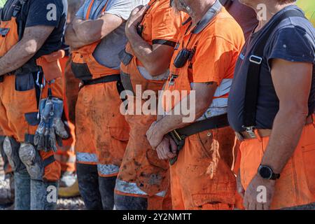 Hamburg, Deutschland. August 2024. Eine Gruppe von Bauarbeitern steht während einer Pause auf einer Baustelle zusammen. Quelle: Markus Scholz/dpa/Alamy Live News Stockfoto