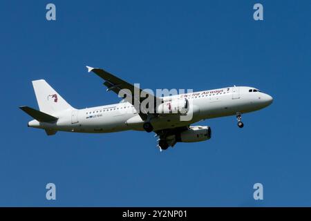 Ein weißes Passagierflugzeug Electra Airways Flugzeug Airbus A320 im Flug vor klarem blauem Himmel, als es sich zur Landung Leipzig Deutschland nähert Stockfoto