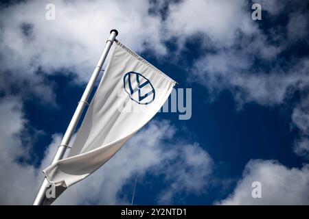 Emden, Deutschland. September 2024. Eine Flagge fliegt auf dem Gelände des VW-Werks in Emden. VW will seine Kostensenkungspläne verschärfen. Es besteht auch die Gefahr, dass Anlagen geschlossen werden. Niedersachsens Ministerpräsident weil sprach mit Arbeitnehmervertretern am VW-Standort Emden über die Situation. Quelle: Sina Schuldt/dpa/Alamy Live News Stockfoto