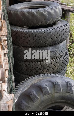 Traktor und Auto legen alte Reifen in einen Stapel Stockfoto