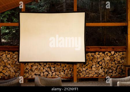 Open-Air-Kino in Holzgartenhaus mit weißer Leinwand Stockfoto