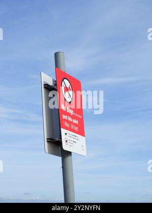 Ein Schild auf einem Wegweiser mit Einschränkungen für Hundespaziergänge am Strand Stockfoto