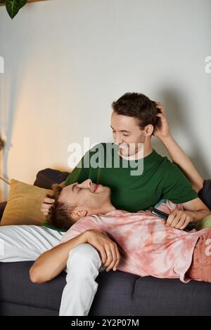 Ein liebevolles Paar teilt einen freudigen Moment auf der Couch. Stockfoto