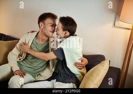 Ein liebevolles Paar genießt eine intime Umarmung auf ihrem Wohnzimmer Sofa. Stockfoto