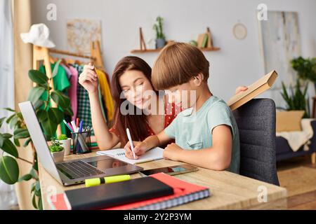 Eine Mutter engagiert ihren Sohn in kreativem Lernen an ihrem gemeinsamen Arbeitsplatz. Stockfoto