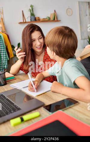 Eine Mutter verführt ihren hörgeschädigten Sohn zu einer freudigen Lernerfahrung. Stockfoto