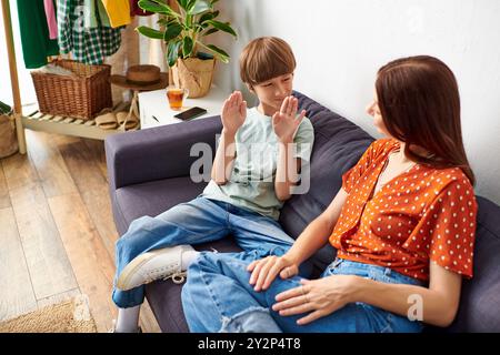 Eine liebevolle Mutter engagiert sich in einer gemütlichen Umgebung mit ihrem hörgeschädigten Sohn. Stockfoto