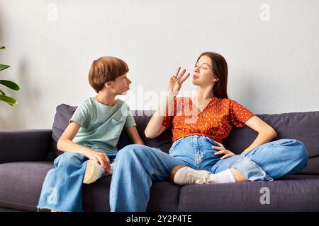 Eine Mutter arbeitet mit ihrem hörgeschädigten Sohn in einer gemütlichen Umgebung in Gebärdensprache. Stockfoto