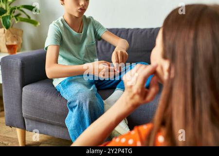 Eine Mutter verwickelt ihren hörgeschädigten Sohn in einen herzerwärmenden Moment der Verbindung. Stockfoto