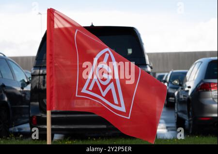 Emden, Deutschland. September 2024. Auf dem Parkplatz des VW-Werks steht eine IG Metall-Flagge. Volkswagen will seine Kostensenkungspläne verschärfen. Es besteht auch die Gefahr, dass Anlagen geschlossen werden. Niedersachsens Ministerpräsident weil sprach mit Arbeitnehmervertretern im VW-Werk Emden über die Situation. Quelle: Alicia Windzio/dpa/Alamy Live News Stockfoto