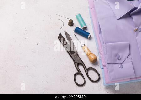 Gefaltete Langarmhemden, Garnspulen, Scheren und andere Werkzeuge für die Reparatur von Heimkleidung mit Kopierraum Stockfoto