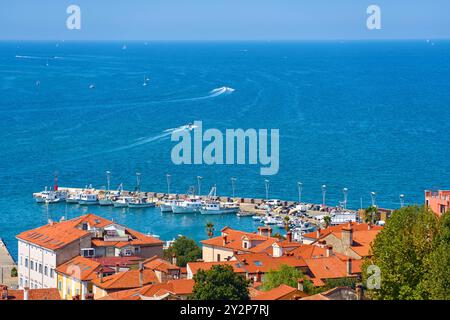 Koper, Slowenien - 25. August 2024: Der Hafen Koper in Slowenien zeigt Fischerboote und Yachten, die in der Adria vor Anker liegen, während sich das weite blaue Meer im Hintergrund erstreckt. Die Altstadt von Koper mit ihren markanten roten Dächern und der lebhaften Hafenatmosphäre lädt zum Entspannen ein *** der Hafen von Koper in Slowenien zeigt Fischerboote und Yachten, die in der Adria ankern, während sich im Hintergrund das weite blaue Meer erstreckt. Die Altstadt von Koper mit ihren markanten roten Dächern und der lebhaften Hafenatmosphäre lädt zum Entspannen und Erkunden ein Stockfoto