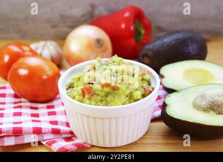 Frisch zubereitete Guacamole mit frischen Avocados und anderen Zutaten Stockfoto