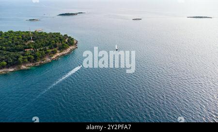 Porec, Istrien, Kroatien - 26. August 2024: Luftaufnahme einer Küstenlandschaft in Kroatien mit einem einsamen Segelboot, das ruhig auf dem Adriatischen Meer segelt *** Luftaufnahme einer Küstenlandschaft in Kroatien mit einem einsamen Segelboot, das ruhig auf dem Adriatischen Meer segelt Stockfoto