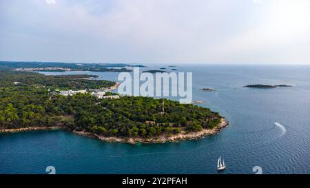 Porec, Istrien, Kroatien - 26. August 2024: Luftaufnahme einer Küstenlandschaft in Kroatien mit einem einsamen Segelboot, das ruhig auf dem Adriatischen Meer segelt *** Luftaufnahme einer Küstenlandschaft in Kroatien mit einem einsamen Segelboot, das ruhig auf dem Adriatischen Meer segelt Stockfoto