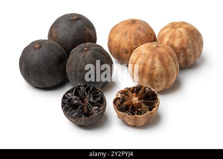 Ganze und halbierte getrocknete schwarze und weiße Limetten, Loomi, isoliert auf weißem Hintergrund, Nahaufnahme Stockfoto