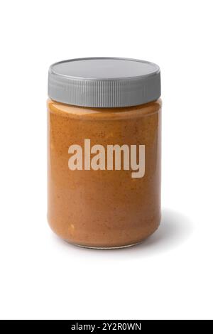 Glasbehälter mit grob gemahlener Erdnussbutter nah oben auf weißem Hintergrund Stockfoto