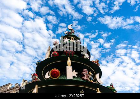 Von unten windet sich eine aufwendig verzierte Weihnachtsbaumskulptur vor einem klaren blauen Himmel, Teil der festlichen Beleuchtung in Tiflis, Georgien Stockfoto