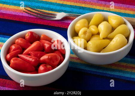 Schüsseln mit eingelegten kleinen roten und gelben scharfen mexikanischen Paprika aus nächster Nähe Stockfoto