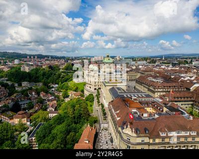 Von oben zeigt diese Drohnenansicht ein geschäftiges Stadtbild in der Schweiz mit historischer Architektur und üppigem Grün unter einem dynamischen Himmel. Stockfoto