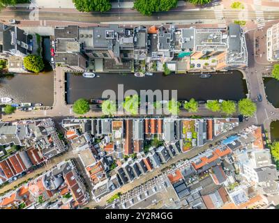 Von oben bietet dieser Blick auf die Drohne einen atemberaubenden Blick auf einen dichten, historischen Grachtenring und die umliegende städtische Architektur in Holland. Klassische Gebäude Stockfoto