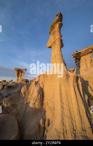 Dramatischer Blick auf die einzigartigen Felsformationen, bekannt als Hoodoos, in der Ah-Shi-SLE-PAH Wilderness, New Mexico, unter einem goldenen Abendhimmel. Stockfoto