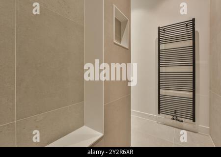 Ein modernes Badezimmer mit einem eleganten, an der Wand montierten Handtuchwärmer und einer eingebauten Nische. Stockfoto