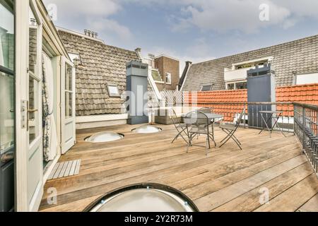 Eine geräumige Dachterrasse mit Tisch und Stühlen inmitten einer urbanen Landschaft mit traditionellen Gebäuden. Stockfoto