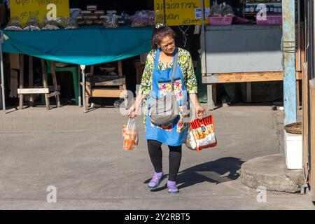 SAMUT PRAKAN, THAILAND, 08. Februar 2023, Eine Frau trägt einen Kauf vom Markt Stockfoto