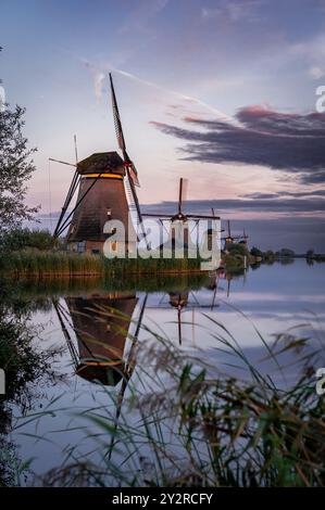 Windmühlen spiegeln sich in den Kanälen in Kinderdijk während des Sonnenuntergangs, Niederlande Stockfoto