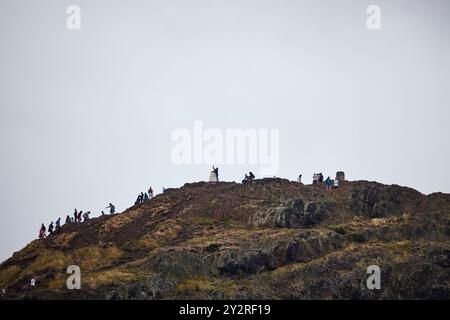 Blick auf Edinburgh von Salisbury Crags, Wanderer erreichen die Spitze von Arthur's Seat Stockfoto