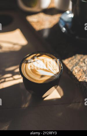 Eine Nahaufnahme eines wunderschön gefertigten Latte mit komplizierten Latte Art in einem gemütlichen Café Stockfoto