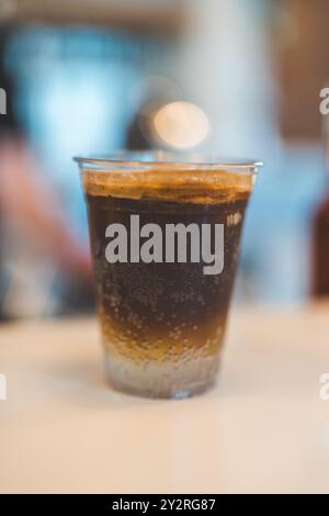 Eine Nahaufnahme eines Glases eisiger Americano mit verschwommenem Hintergrund in einem Café. Stockfoto