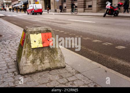 Betonbarriere mit gelber und roter Farbe auf dem Bürgersteig der Stadt Stockfoto