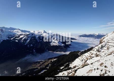 Hochgebirgslandschaft mit einem Wolkenmeer, das das Tal zwischen der schneebedeckten Landschaft bedeckt Stockfoto