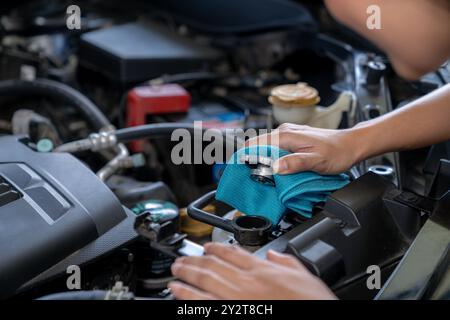 Die junge Frau überprüft den Kühler des Autos Stockfoto