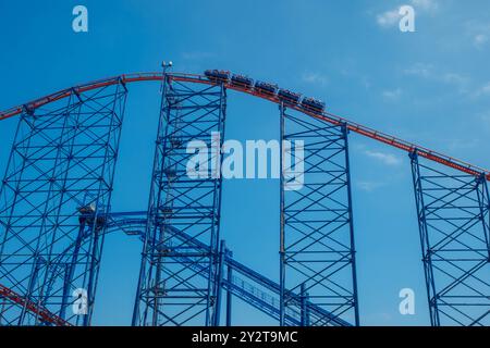 Die Big One Achterbahn am Blackpool Pleasure Beach ist eine hochaufragende Stahlkonstruktion, die vor einem hellblauen Himmel steht. Das Bild zeigt den Drag der Fahrt Stockfoto