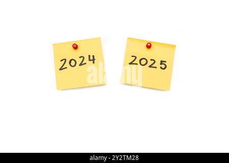 Zwei gelbe Haftnotizen mit 2024 und 2025 auf weißem Hintergrund mit Kopierraum Stockfoto