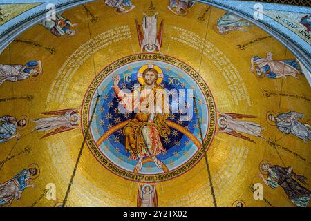 Belgrad, Serbien - 29. April 2024: Kunstvolle Mosaikkunstwerke Christi mit Engeln zieren die Decke der Kirche Sankt-Sava, die mit Gold glänzt Stockfoto