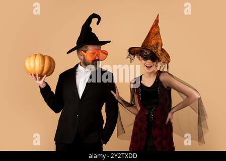 Lustiges Paar mit Halloween Kürbis. Porträt von Mann und Frau in Halloween-Hut mit Kürbis. Trick or Treat. Beängstigendes Hipster-Paar mit Halloween-Hut. Stockfoto