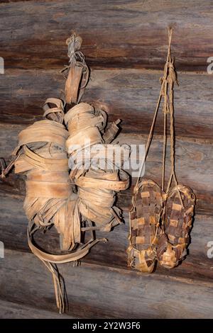 Gewebte Bastschuhe hängen an der Wand. Paar gewebte Schuhe Stockfoto