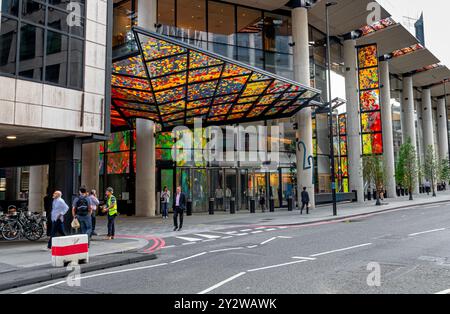 Leute laufen unter dem bunten Glasdach am Eingang zum 22 Bishopsgate, einem Wolkenkratzer in der City of London, London, Großbritannien Stockfoto