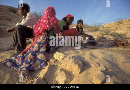 Eine Rajasthani-Frau hackt mit ihrem Baby in der Stadt Jaisalmer in der Provinz Rajasthan in Indien an einem Feuer. Indien, Jaisalmer, Januar 1998 Stockfoto