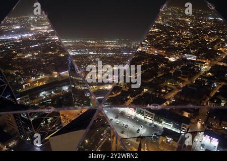 Riad, Saudi-Arabien – 11. September 2024: Die saudische Hauptstadt Riad in der Nacht spiegelt sich in der Welt des Al-Faisaliah-Turms wider Stockfoto