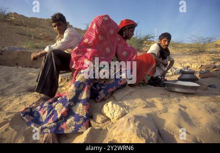 Eine Rajasthani-Frau hackt mit ihrem Baby in der Stadt Jaisalmer in der Provinz Rajasthan in Indien an einem Feuer. Indien, Jaisalmer, Januar 1998 Stockfoto