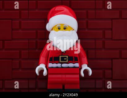 Tambow, Russische Föderation - 21. August 2024 Porträt der Minifigur Lego Santa Claus vor rotem Backsteinmauerhintergrund. Stockfoto