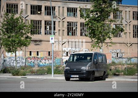 Ein alter Fiat Ducato Van der zweiten Generation aus dem Jahr 1993 parkte im alten Industriegebiet von Barcelona. Dahinter befindet sich eine alte verlassene Fabrik Stockfoto